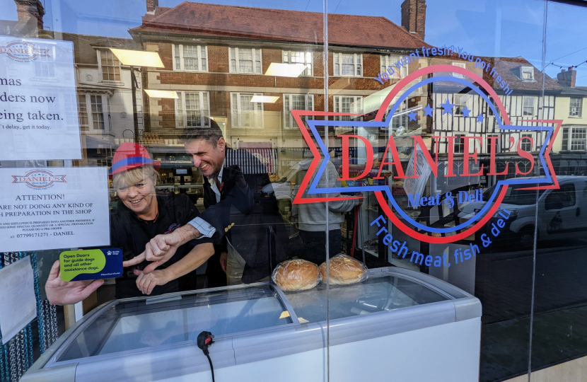 Ben Everitt MP And Daniel's Fish, Meat & Deli In Newport Pagnell Putting Up A Guide Dogs Sticker